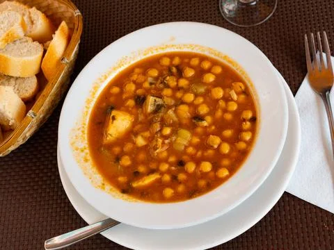 Stew boiled soup prepare of cod fillet, potatoes, chickpeas in tomato sauce. Stock Photos