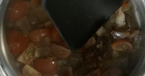 Stew cherry tomatoes in a saucepan. Chef stirs the tomatoes with a spatula 動画素材 247641987