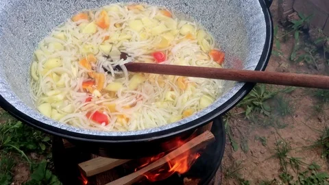 A stew cooked in cauldron over fire Stock Footage 95070405