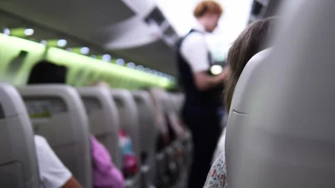 Steward explaining safety procedures to passengers on plane steward engages with Stock Footage 280080217