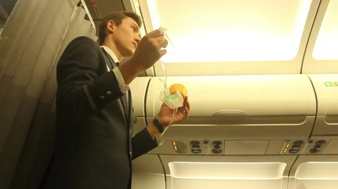 Steward on the plane shows how to use an oxygen mask Video stock 59713107