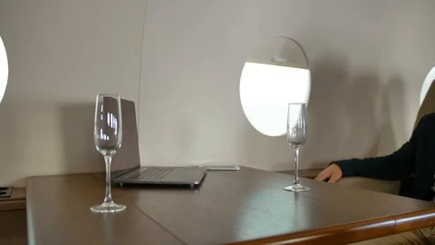 Stewardess bring champagne to entrepreneur inside of private jet Stock Footage 114169953