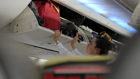 Stewardess closing the Luggage Compartment with Difficulty. Stock Footage 89608660