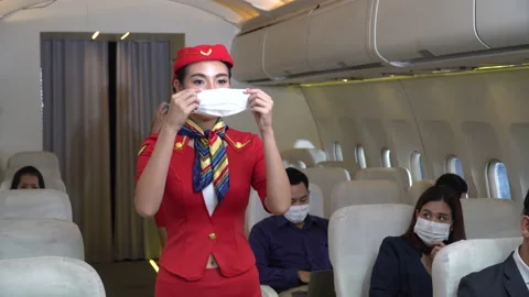 Stewardess demonstrate wearing protective face mask in airplane new normal of Stock Footage 147237217