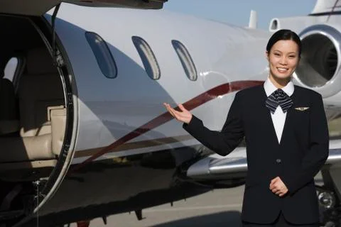 Stewardess Gesturing At Airfield Stock Photos