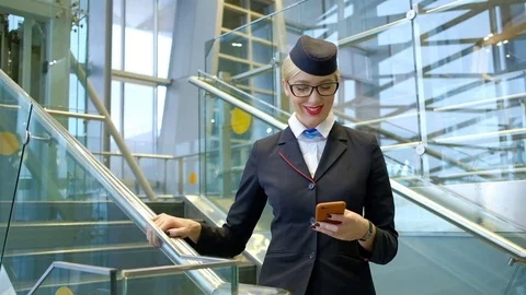 Stewardess with glasses reading a message on your phone and smiling Stock Footage 72053957
