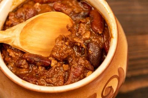 Stewed beans with meat in a small pot. A traditional rustic dish. Close-up, s Stock Photos