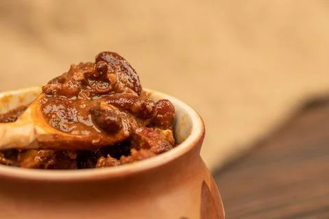 Stewed beans with meat in a small pot. A traditional rustic dish. Close-up, s Stock Photos