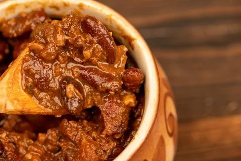 Stewed beans with meat in a small pot. A traditional rustic dish. Close-up, s Stock Photos