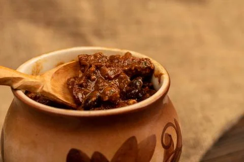 Stewed beans with meat in a small pot. A traditional rustic dish. Close-up, s Stock Photos