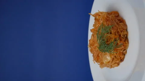 Stewed cabbage in a rotating plate on a blue background. Ready meal, Stock Footage 163901799