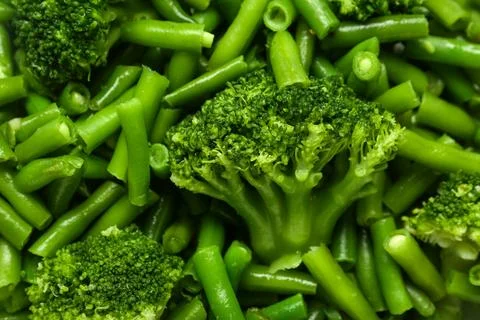 Stewed green beans with broccoli as background, closeup Stock Photos