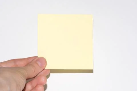 Stick note isolated on white background. Yellow post-it note with hand Stock Photos
