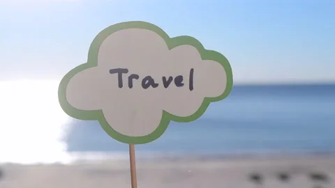Stick with paper speech bubble with words Travel on background sea, sky, sandy Stock Footage 219777312