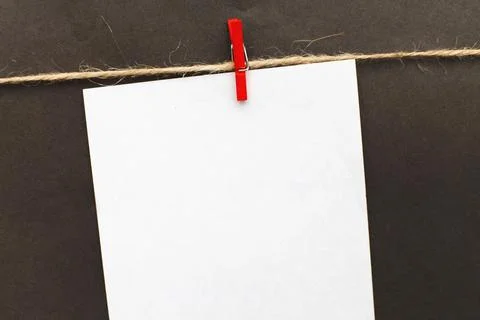 Sticker with empty mockup for text hanging on a pin on black background. Fotos Stock