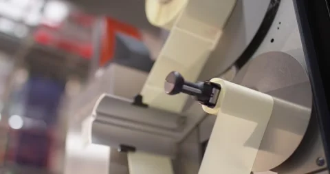 Sticker roll runs through a labelling machine in a factory, Food Industry Stock Footage 340040451