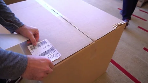 Sticking Down Postage Label on Cardboard Package Video stock 82812772