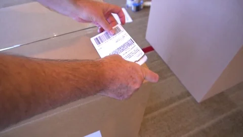 Sticking Down Postage Label on Cardboard Package Video stock 82812882