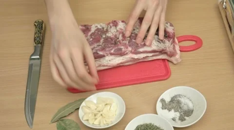 Sticking thin slices of garlic in salted and peppered bacon. Stock Footage 7740848