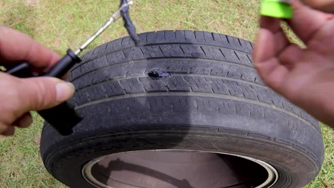 Sticking tire plug tool into a tire with pressure by a person Stock Footage 164262089