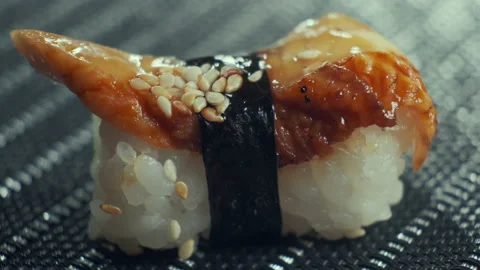 Sticks taking sushi from table, Closeup of eating tasty sushi rolls filled with Stock Footage 147756379