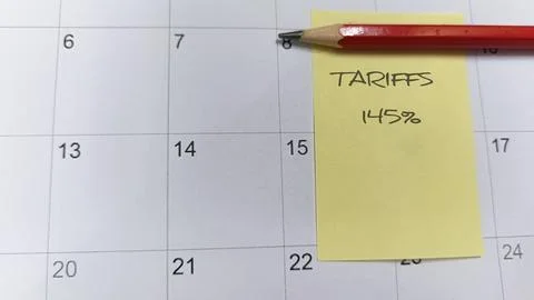 A sticky note on a calendar marked "Tariffs" draws attention to a specific .. Stock Photos