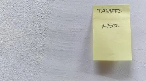 Sticky note on a cracked wall representing the effects of a tariff increase. Stock Photos