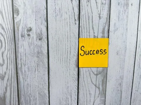 Sticky note featuring the word Success placed on a textured wooden background Stock Photos