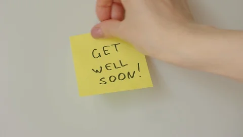 Sticky note Get well soon being sticked to white surface Stock Footage 128058825