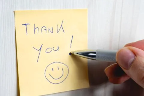A sticky note hanging on the wall, with the text Thank You on it. Foto stock