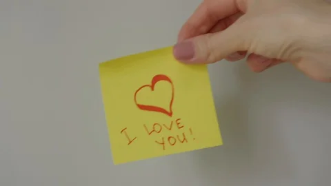 Sticky note I love you being sticked to white surface Stock Footage 128058859