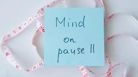 Sticky note with message on pause surrounded by measuring tape Stock Photos