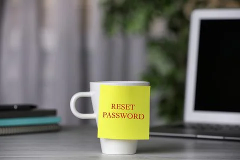 Sticky note with phrase Reset Password on cup indoors Stock Photos