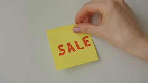 Sticky note Sale being sticked to white surface Stock Footage 128058857