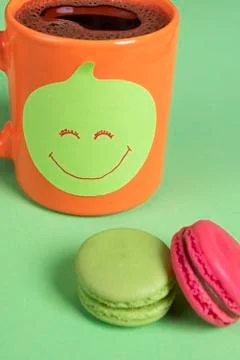 Sticky note with smiley face on a cup of coffee.  Office desk with cookies an Stock Photos