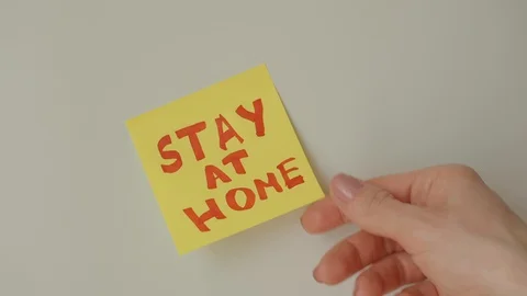 Sticky note Stay at home being taken off from white surface Stock Footage 128058856