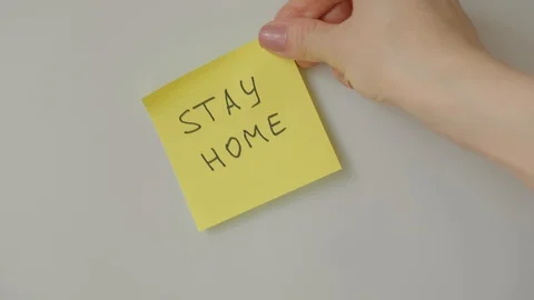 Sticky note Stay home being sticked to white surface Stock Footage 128058925