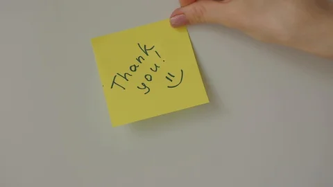 Sticky note Thank you being sticked to white surface Stock Footage 128058932