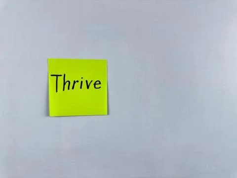 Sticky note with Thrive written on it, affixed to a white background. This .. Stock Photos