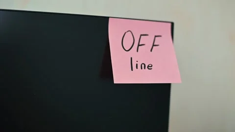 A sticky note with the word OFF line is attached to a black monitor in a simple Video stock 339094051