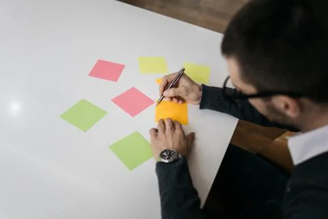 Sticky notes and man's hands on office table Foto stock