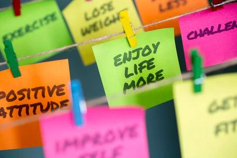 Sticky notes hanging with important message to enjoy life more Colorful st... Stock Photos