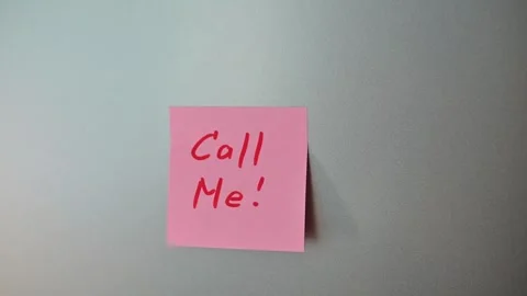 Sticky notes with the message to call are placed on a gray wall in an office. Stock Footage 339096554