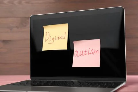 Sticky notes with phrase Digital Autism attached to laptop on table, closeu.. Stock Photos