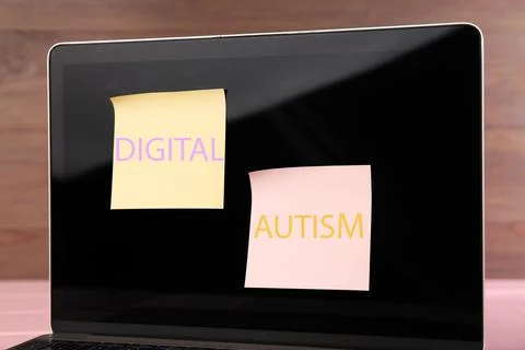 Sticky notes with phrase Digital Autism attached to laptop on table, closeu.. Stock Photos