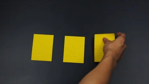 Sticky notes putting by hand on black board Stock Footage 90385770