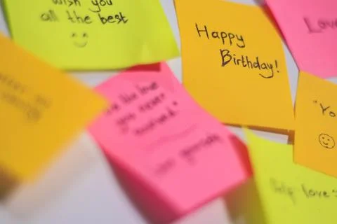 Sticky notes stuck to the wall saying happy birthday Stock Photos