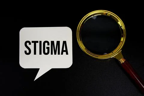 Stigma text on speech bubble with magnifying glass top view on black backgrou Stock Photos