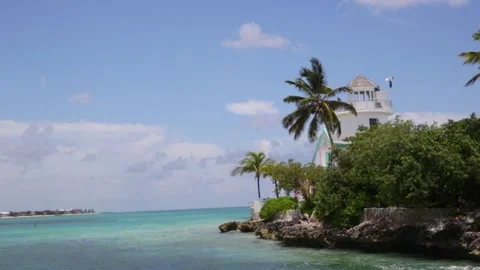 Still camera view of tropical lighthouse overlooking clear blue ocean Stock Footage 284168877
