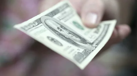 Still hand offering a $100 bill. Money in focus, background blur Stock Footage 55445720